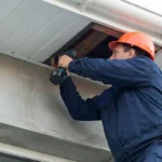 Professional Fascia Board Check or Replacement Toronto inspecting wood rot behind gutters by CNG Contracting.