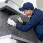 Professional Furnace & Hood Vent Filter Replacement Toronto sliding new filter into HVAC unit by CNG Contracting.