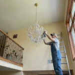 Professional Light Bulbs & Chandelier Cleaning Toronto polishing crystals on a high fixture by CNG Contracting.