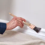 Professional Trim, Baseboard & Door Painting Toronto sanding wood trim for smooth finish by CNG Contracting.