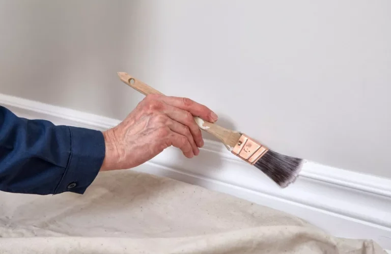 Professional Trim, Baseboard & Door Painting Toronto sanding wood trim for smooth finish by CNG Contracting.