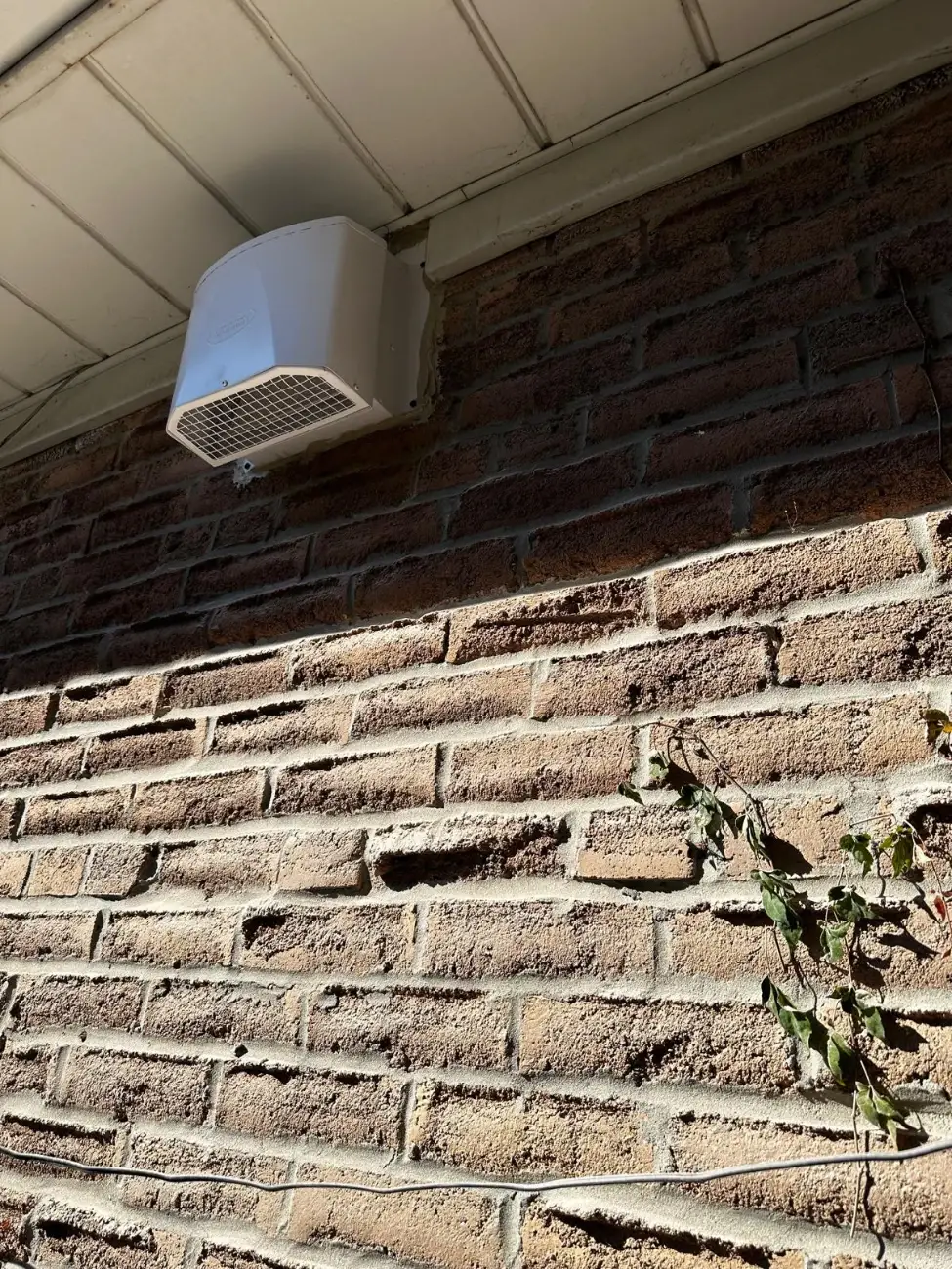 New range hood vent cap under the soffit of a Mississauga brick home