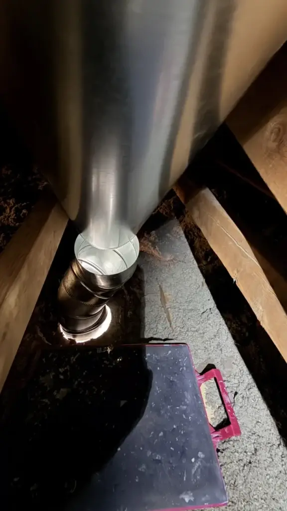 Rigid metal range hood duct running up through the attic