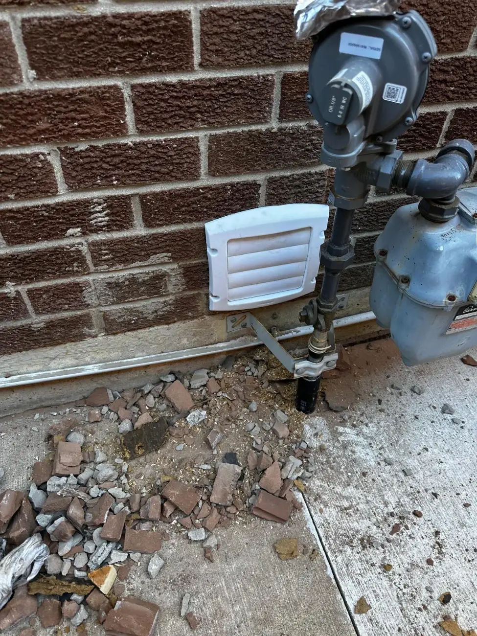 New louvered range hood vent cap on the brick wall of a Toronto home