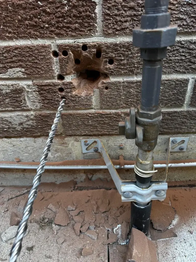 Duct hole through the brick wall next to the gas line
