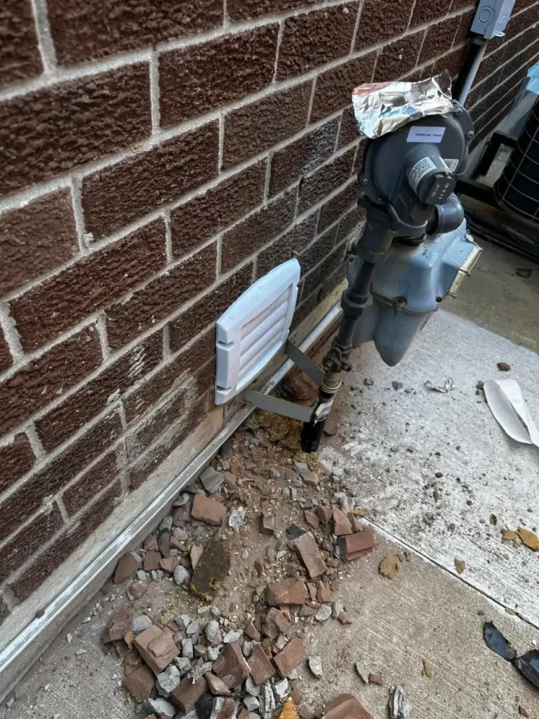Vent cap installed with brick debris still on the ground